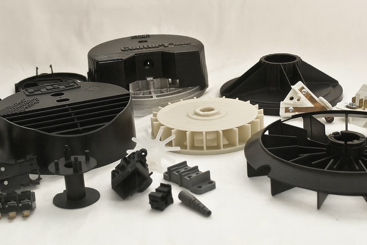 Injection molded plastic parts for electrical and electronic applications, featuring housings, fan blades, connectors, and insulating components.