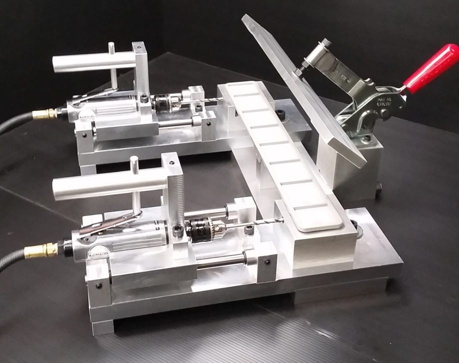 Dual-station pneumatic drilling and clamping fixture with machined aluminum baseplates, toggle clamp, and guided air-drill spindles for repeatable holemaking in multi-axis CNC machining workflows.